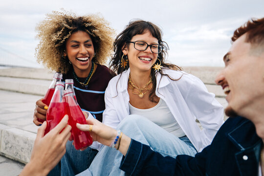 Friends cheering with drinks in a candid outdoor moment