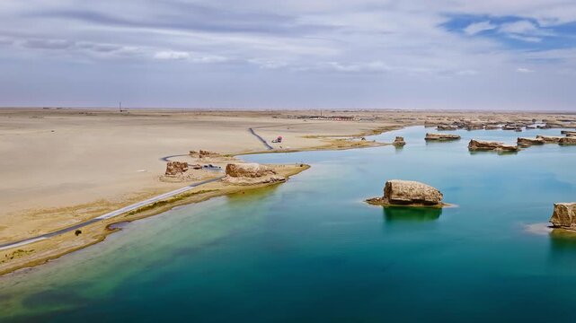 Aerial view of water yardang geological landforms and a turquoise lake in Qinghai, China