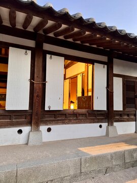 Warm light shining through open traditional sliding doors of Hanok house