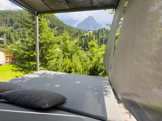 Obraz premium Modern patio furniture with sofa. Overlooks rich green mountain landscape. Sunny day bright airy atmosphere. Perfect outdoor living space