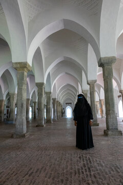 Woman standing among the pillars inside the Sixty Dome Mosque, Khulna Division, Bagerhat, Bangladesh