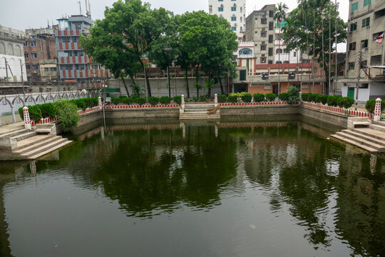 Reflecting pond bordered by red and white pillars in the Hussaini Dalan shrine complex, Dhaka Division, Dhaka, Bangladesh