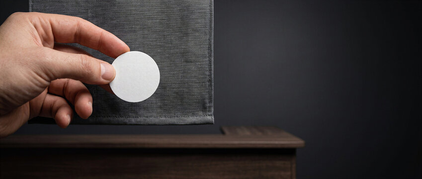 Hand Holding Blank Round Tag Beside Gray Shopping Bag