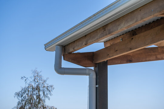 A rainwater gutter and PVC downpipe installed on timber roof beams of an outdoor park shelter&nbsp;in Australia.