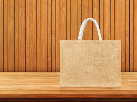 Natural fiber reusable grocery bag on empty wooden desk with copy space.