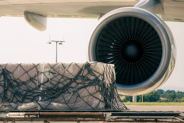 Preparation freight airplane at airport. Loading of cargo containers to plane. Air logistics, global freight transportation and aviation industry concept. © Chalabala