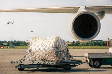 Preparation freight airplane at airport. Loading of cargo containers to plane. Air logistics, global freight transportation and aviation industry concept. © Chalabala