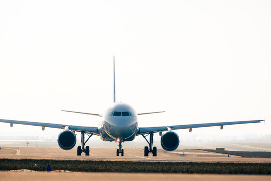 Front view of commercial airplane during taxiing on taxiway to airport runway for take off.