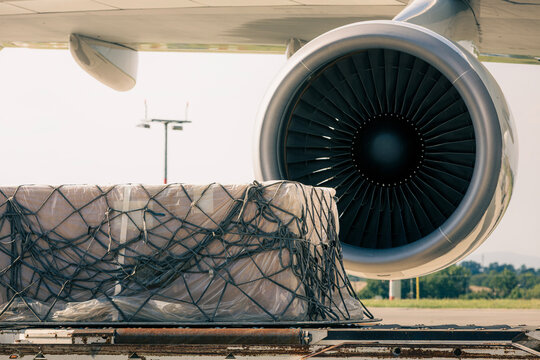 Preparation freight airplane at airport. Loading of cargo containers to plane. Air logistics, global freight transportation and aviation industry concept.