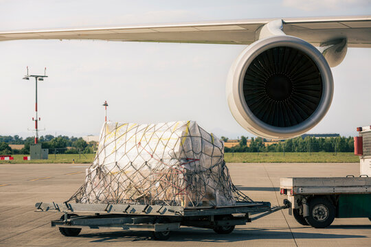 Preparation freight airplane at airport. Loading of cargo containers to plane. Air logistics, global freight transportation and aviation industry concept.