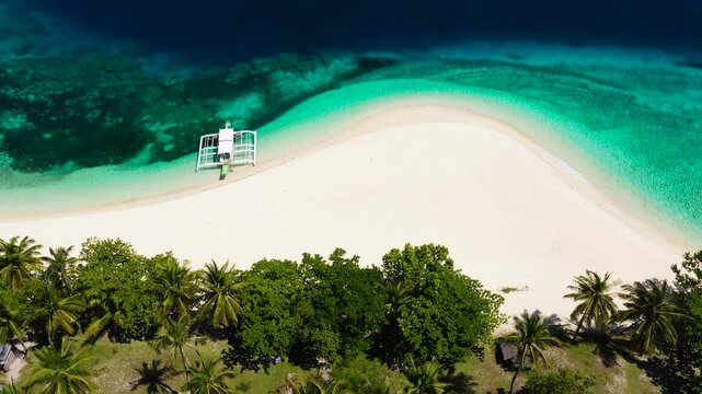 Beautiful lagoon and white sandy beach, aerial view.Tourist boat off the coast. Perfect white sand beach with tropical trees. Mahaba Island, Philippines. Summer and travel vacation concept.