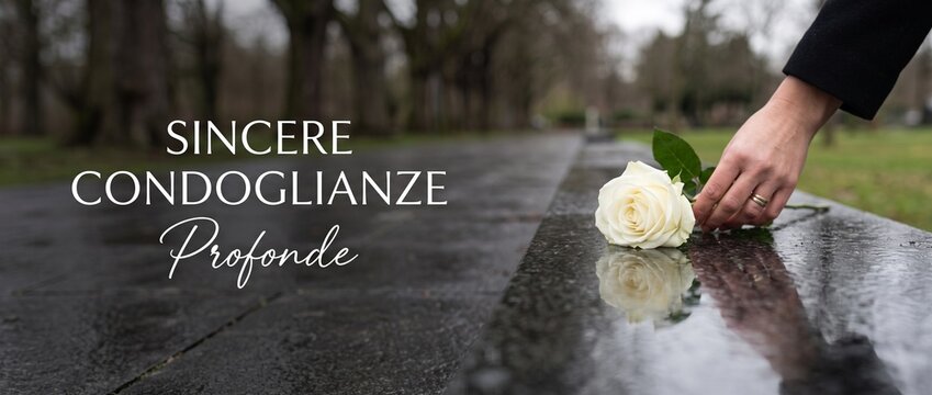 White rose funeral gravestone hand placing flower on cemetery monument with Italian text Sincere Condoglianze Profonde for sympathy, grief, loss, mourning, tribute, memory, condolence banner backgroun