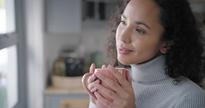 African American woman at kitchen window holding pink mug savoring aroma glancing to camera smiling