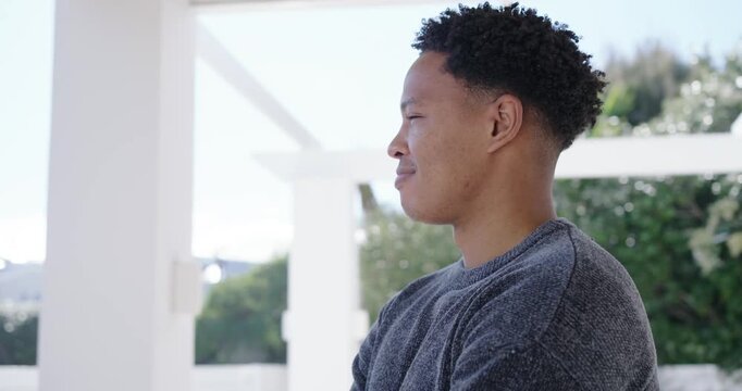 African American man posing under pergola in sweater from camera move, smiling, laughing