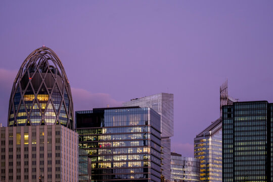 Modern office towers and glass architecture shape a dense Paris skyline in France at dusk with illuminated windows and layered urban buildings