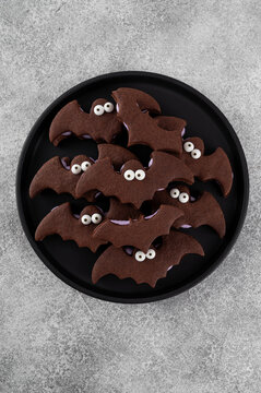 Halloween cookies. Chocolate sandwich cookies in the shape of a bat with eyes and butter cream. Funny food idea. Top view.