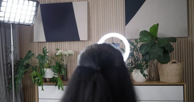 Diverse female friends recording at studio, ring light turning on, host adjusting, unboxing shades