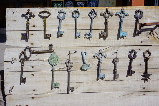 Collection of vintage souvenir keys hanging on wooden board