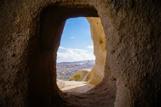 Cappadocia valley view framed by ancient cave opening and stone window