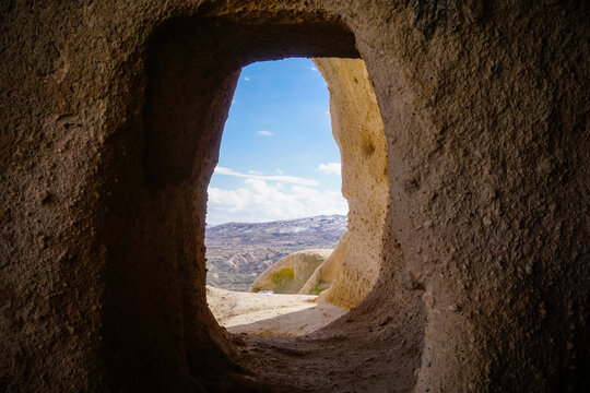 Cappadocia valley view framed by ancient cave opening and stone window