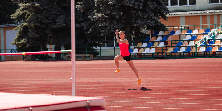 Adult high jumper accelerates along curved approach toward bar. Concept of run up rhythm, speed development, concentration, technique and track training.