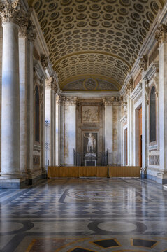 The monumental portico of the Archbasilica of Saint John Lateran in Rome, Italy, featuring a coffered ceiling and the ancient statue of Constantine