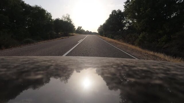 Driving Into Blinding Sunset on Empty Rural Asphalt Road