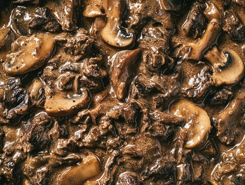A detailed close up of beef stroganoff with mushroom sauce, showcasing tender beef and sliced mushrooms in a rich, creamy sauce.