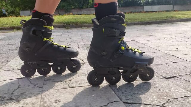 POV side view of roller skating on park broken tiles path with raw rolling wheels sound