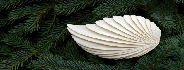 Fototapeta premium Delicate white feather angel wings gracefully dangling from a tree as a charming Christmas ornament adding magic to the holiday season