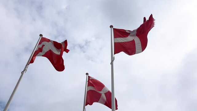 Three Danish flags waving in slow motion