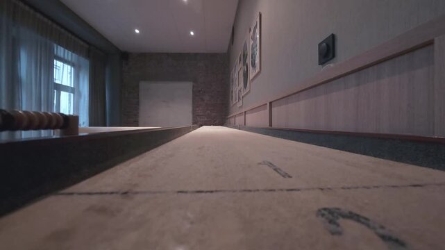 Low angle view along an empty table shuffleboard in a lounge