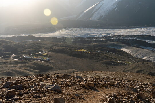 Lenin Peak Camp 1's tent camps seen from a hill, sunrise in Kyrgyz Mountains