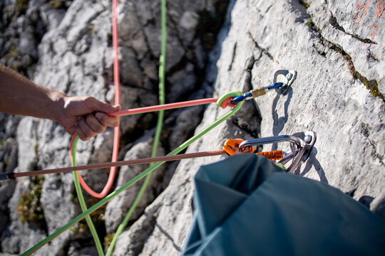 Improperly rigged multi pitch climbing belay station with a clove hitch on one anchor and no connection between two bolt anchors, illustrating anchor safety and redundancy risks 