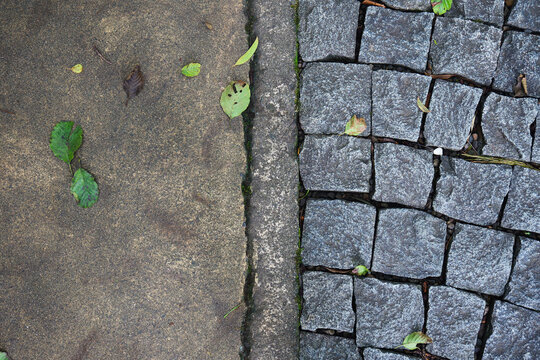 Cobblestone and concrete pavement dividing urban ground