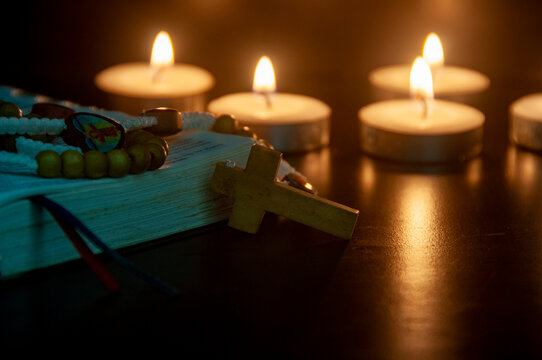 Holy Rosary with blurred candle light representing Christianity Faith.