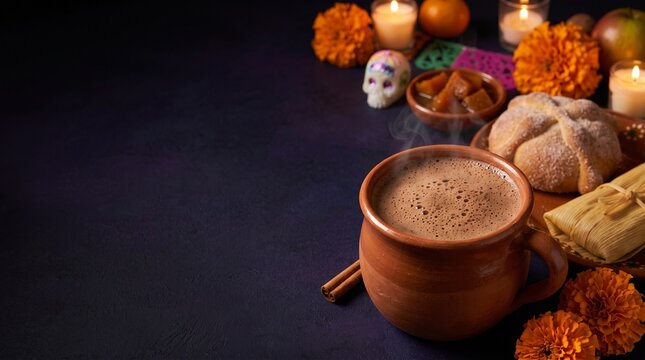 Mexican Hot Chocolate with Pan de Muerto Tamales and Marigolds on Dark Day of the Dead Table