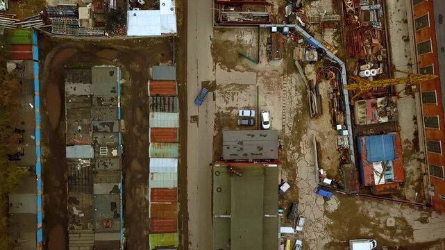 Aerial top down view of industrial district and garage cooperative with car driving on road