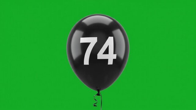 Black balloon with number 74 floating on green screen
