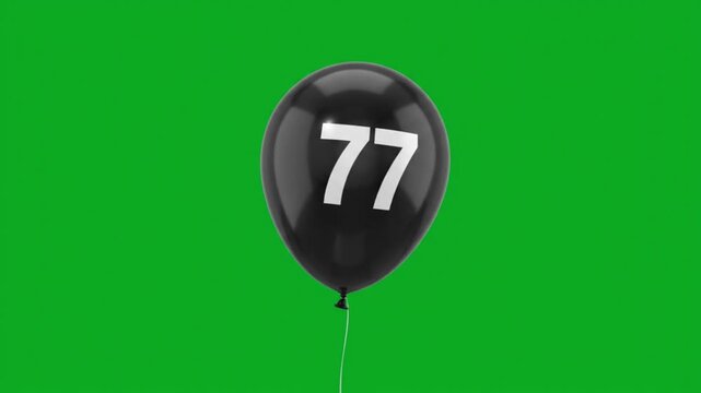 Black balloon with number 77 floating on green screen