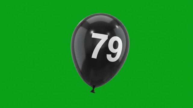 Black balloon with number 79 floating on green screen