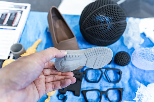 hand with 3d printed shoe figure close-up