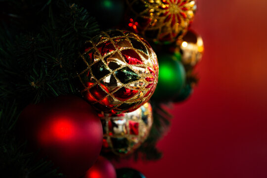 Boules de No&euml;l color&eacute;es rouges, vertes et dor&eacute;es sur fond rouge