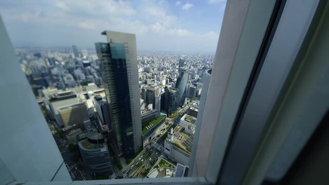 Tilt shift style time lapse of busy Nagoya city center and high rise buildings from above