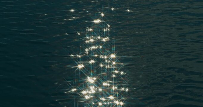 Bright reflections sparkle across rippling dark water. Star-shaped highlights drift over a textured blue water surface.