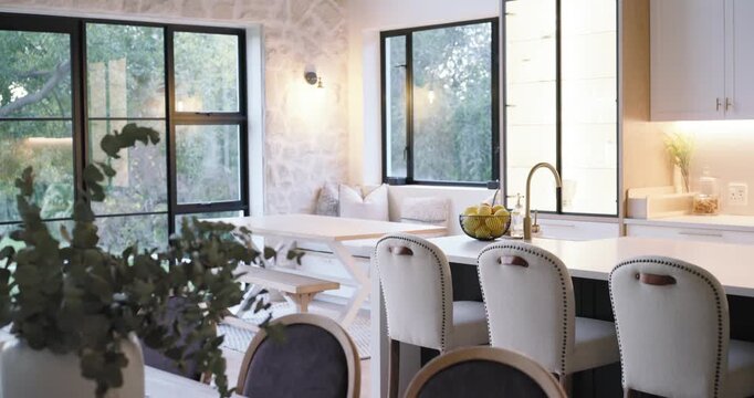 Slow camera is panning from left window, revealing kitchen island and stools to showcase design