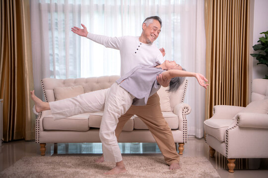 Senior couple practicing dance and balance exercises together at home,