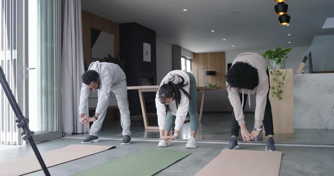 African friends starting warm-up by raising arms, stretching on exercise mats near glass doors