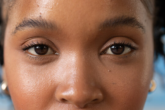 African American woman looking at camera in studio close-up with catchlit eyes and gold hoops