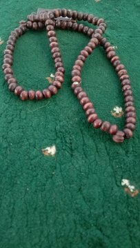Traditional Wooden Tasbih Prayer Beads Resting on a Green Prayer Mat